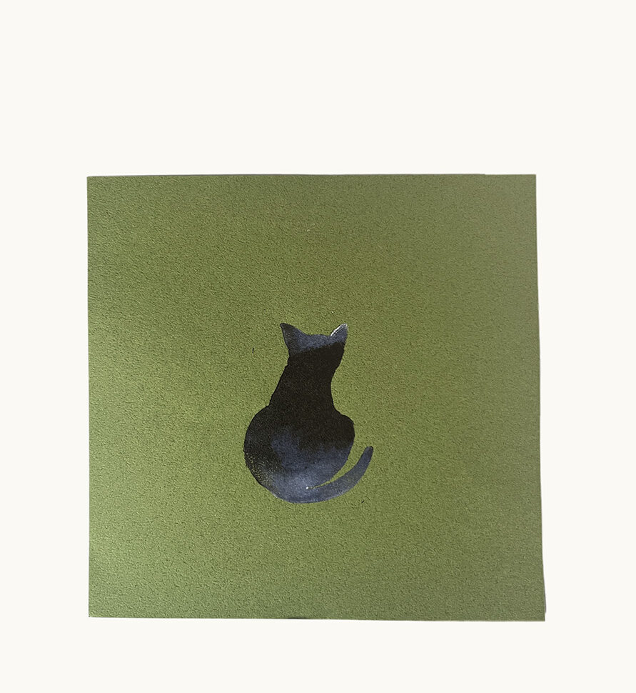 print on green paper square of black and grey cat as seen from behind.